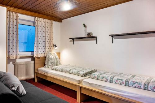 卡雷扎湖Sirena Carezza Apartment Karersee的一间设有两把长椅的房间,房间设有窗户
