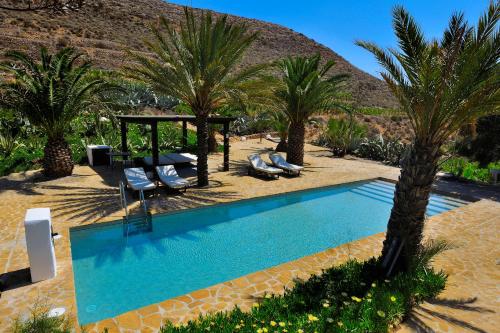阿瓜阿马加伊尔吉塔诺阿尔门德拉酒店的一个带棕榈树和凉亭的游泳池