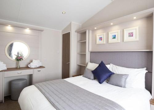 LendalfootBennane Shore Holiday Park的卧室配有带蓝色枕头的大型白色床