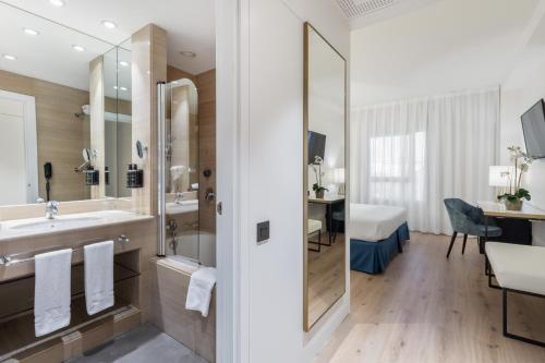 阿尔考本达斯欧洲之星格兰马德里酒店的一间带水槽和淋浴的浴室以及一张书桌