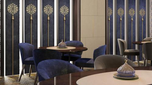 阿可贺巴Holiday Inn & Suites - Al Khobar, an IHG Hotel的一间配备有桌子和蓝色椅子的用餐室