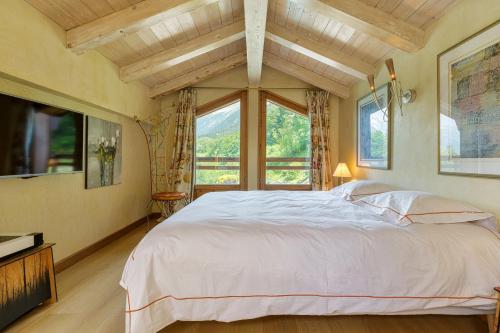 里雾诗Chalet Galadhrim Chamonix Mont Blanc Valley的一间卧室设有一张大床和一个大窗户