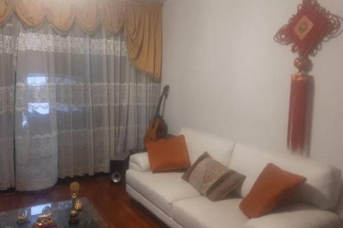 利马Amplio Departamento Residencial en La Molina的客厅配有白色沙发和吉他