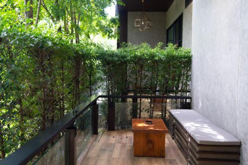 农布La Miniera Pool Villas Pattaya - SHA Plus的阳台配有长凳和桌子