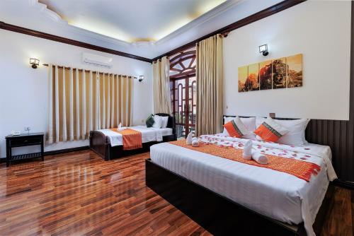 暹粒Siem Reap Urban Boutique Hotel的酒店客房配有两张床和一张书桌