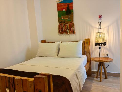 萨兰托Hotel Salento Mirador的一间卧室配有一张床、一张桌子和一幅画