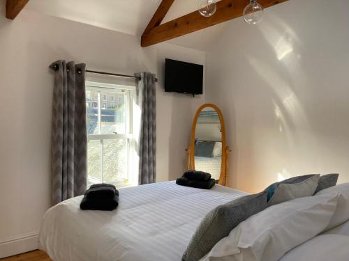 梅瓦吉西Finest Retreats - Backlet Cottage - Mevagissey Cottage Sleeps 4的一间卧室配有一张床、镜子和窗户