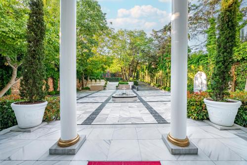 伊斯坦布尔博斯普鲁斯宫酒店的一座拥有白色柱子和喷泉的花园