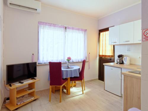 诺维格勒伊斯特拉Apartments Marta的厨房配有桌椅和电视。