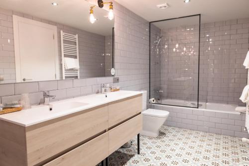 坎普罗东Hotel Cims de Camprodon的一间带水槽、浴缸和卫生间的浴室