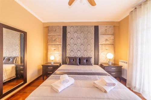 瓦戈斯Boa Vida Alojamentos的一间卧室配有一张大床和两条毛巾
