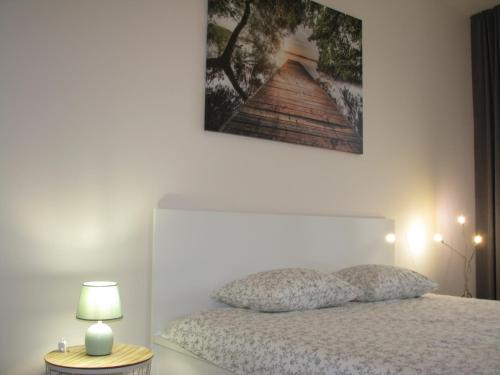 比亚韦斯托克4You Apartament的卧室配有一张床,墙上挂着一幅画