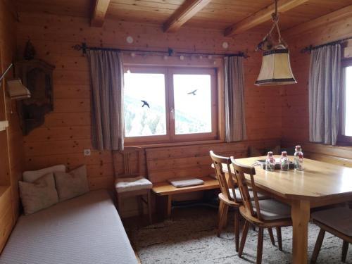 图尔菲斯Walters Hütte的木制用餐室设有桌子和窗户