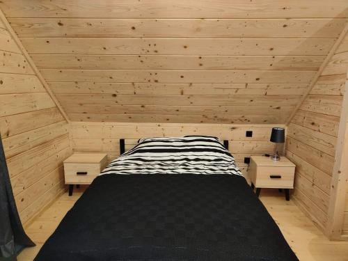 斯派特克维瑟beskid house的木制客房内的一间卧室,配有一张床