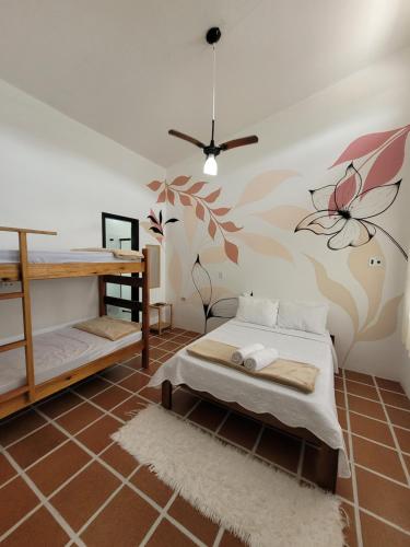 乌巴图巴Aldeia Ubatuba的卧室配有一张床,墙上挂着花壁画