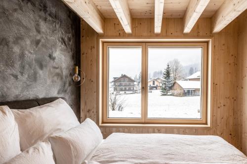 梅劳Haus im WALDner的一间卧室设有一张床和一个大窗户