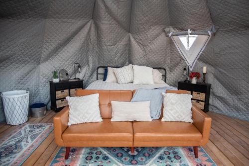 New HarmonyLittle Village Retreat的帐篷内的沙发,配有一张床