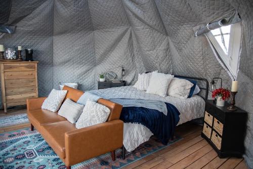 New HarmonyLittle Village Retreat的一间卧室配有一个带一张床和一张沙发的帐篷