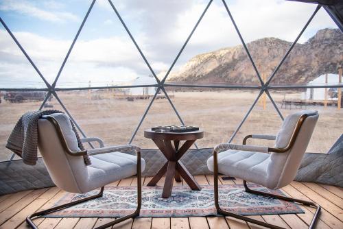 New HarmonyLittle Village Retreat的门廊上的两把椅子,享有沙漠美景
