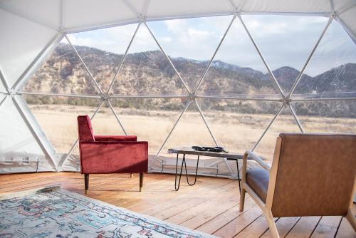 New HarmonyLittle Village Retreat的帐篷内的房间,配有两把椅子和一张桌子