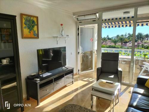 英格兰海滩Sunny Apartment Teneguia by Yumbo的客厅配有平面电视和椅子。