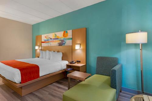 里士满Best Western PLUS Executive Hotel Richmond的配有一张床和一把椅子的酒店客房