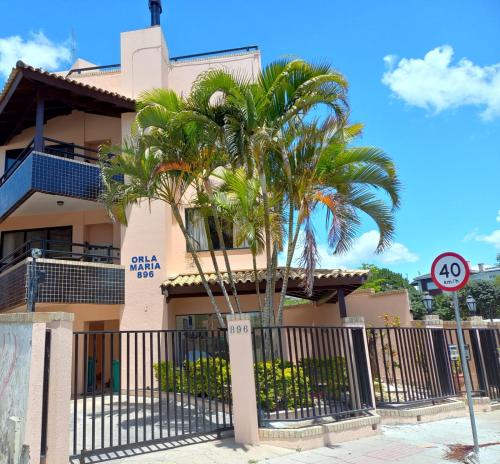 弗洛里亚诺波利斯Orla Maria Apartamentos的一座棕榈树建筑