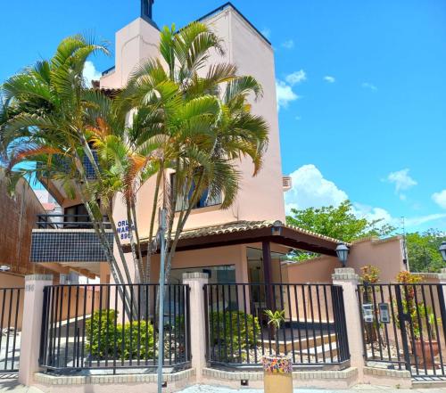 弗洛里亚诺波利斯Orla Maria Apartamentos的前面有棕榈树的房子