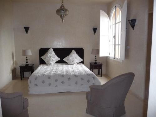 塔鲁丹特Palais Villa Talaa Resort的卧室配有白色的床和2把椅子