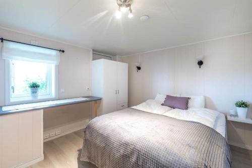 特罗姆瑟Spacious modern apartment, close to nature的白色的卧室设有床和窗户