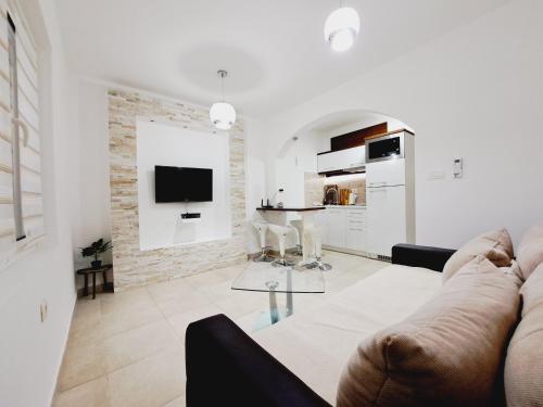 蒂瓦特普诺维科公寓的白色的客厅配有沙发和桌子