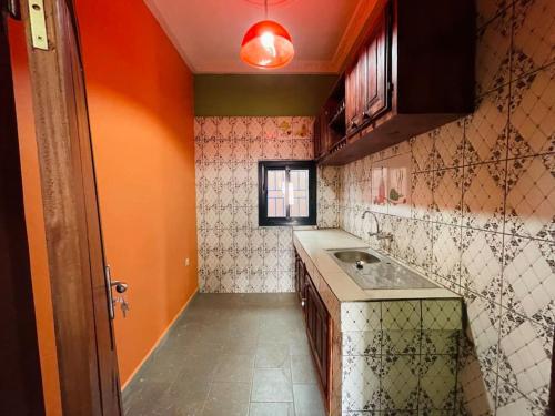 BafoussamCharmante maison cozy et conviviale的一个带水槽和橙色墙壁的小厨房