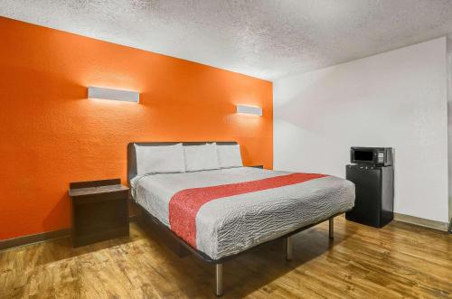 克洛维斯Motel 6-Clovis, NM的橙色墙壁间的一张床位