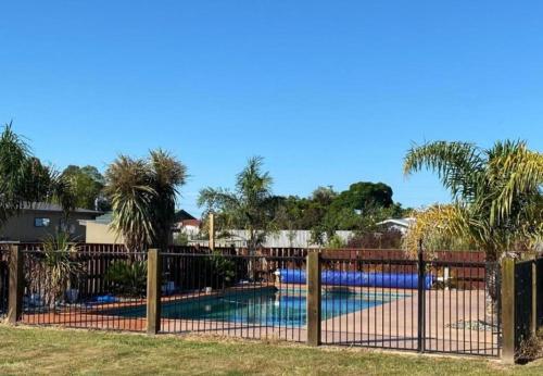 HopeCountry Retreats On Ranzau 4的游泳池位于带游泳池的围栏后方