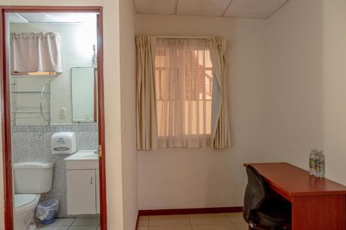 圣萨尔瓦多温莎广场酒店的一间带卫生间、水槽和窗户的浴室