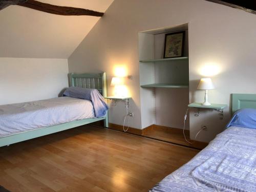 Moncé-en-BelinGîte Moncé-en-Belin, 4 pièces, 11 personnes - FR-1-410-248的一间卧室设有两张床,铺有木地板。