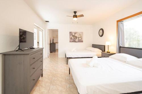 彭布罗克派恩斯Waterfront 2-Story Villa with Heated Pool的一间卧室配有两张床和电视。