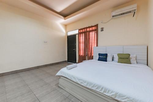 StalkudoUrbanview Hotel Garuda Sky Inn Balikpapan by RedDoorz的卧室配有白色的床和窗户。