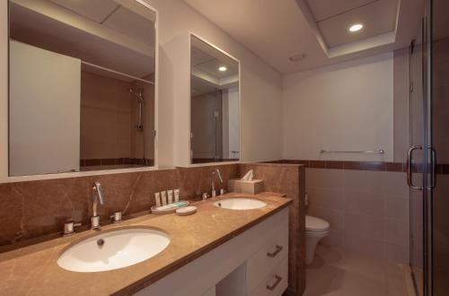 迪拜Signature Burj Khalifa And Fountain View Residence的浴室设有2个水槽、卫生间和镜子。