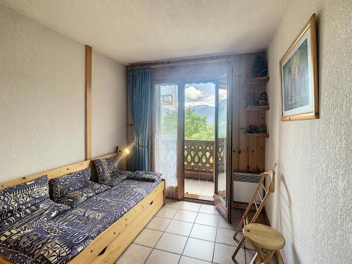 孔布卢Appartement Combloux, 3 pièces, 6 personnes - FR-1-560-5的一间卧室设有一张床,享有阳台的景色
