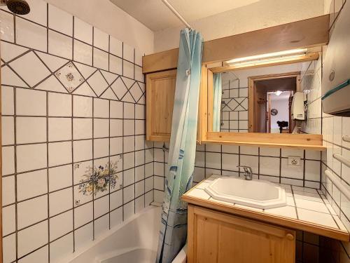 孔布卢Appartement Combloux, 3 pièces, 6 personnes - FR-1-560-5的一间带水槽、浴缸和镜子的浴室
