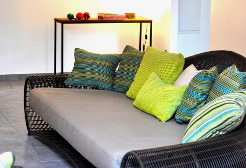 圣皮埃尔Les Patios de Grands Bois的柳条沙发,上面有色彩缤纷的枕头