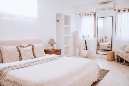 坎古Hotel Sages的白色卧室设有一张大床和镜子
