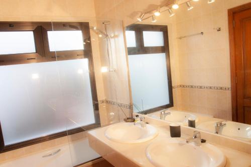 普拉亚布兰卡El jardín de Juanita - ROOMS的浴室设有2个盥洗盆、淋浴和镜子。