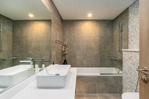 迪拜Vacay Lettings - Waterfront Luxury home with full Marina view的带浴缸和盥洗盆的浴室