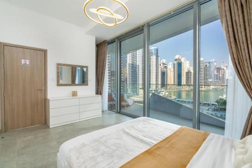 迪拜Vacay Lettings - Waterfront Luxury home with full Marina view的一间卧室设有一张床和一个大窗户