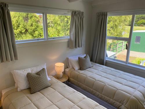 皮克顿Sounds Good - Waikawa Holiday Home and Berth的一间卧室设有两张床和两个窗户。
