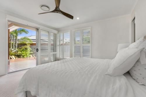 努萨角Key Ct 10的白色卧室配有床和吊扇