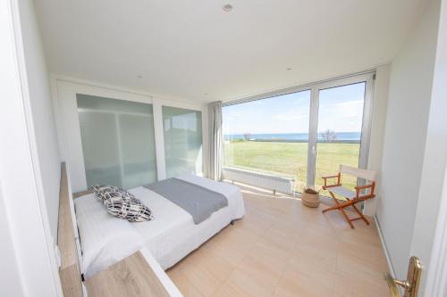 福斯Apartagal- Casa Playa, Foz的一间卧室设有一张床和一个大窗户