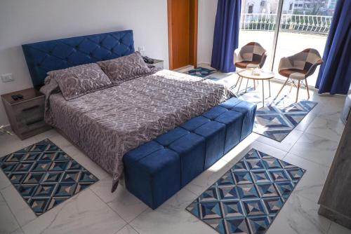Zefta济夫塔礁酒店的一间卧室配有蓝色的床和两把椅子